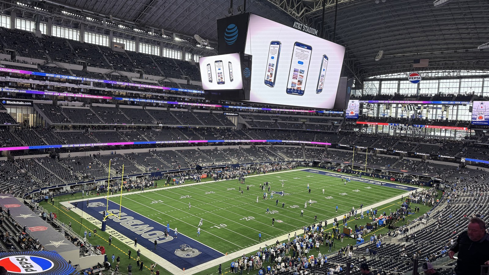 Inside AT&T Stadium in Arlington, Texas, with the Cowboys end zone and the giant video board over the field before a December 2025 game